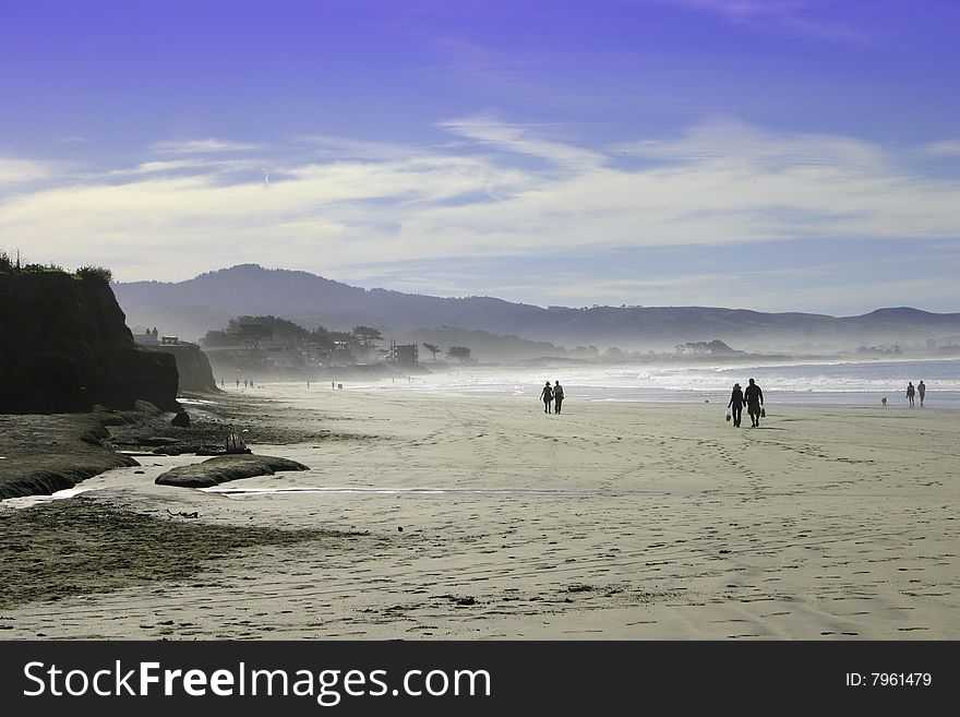 Silhoutted people walking on a beach in California. Silhoutted people walking on a beach in California