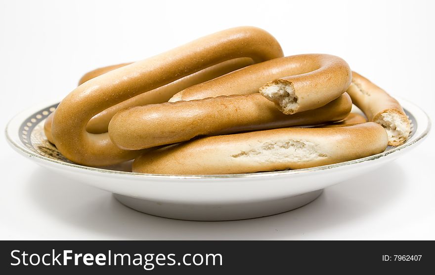 Several bagels on saucer with ornament on white