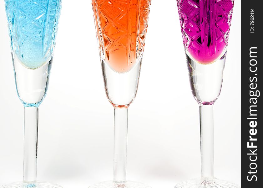 Three wineglass with drink blue, red and magenta colors