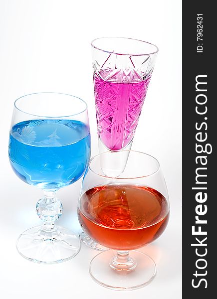 Three wineglass with drink blue and magenta colors