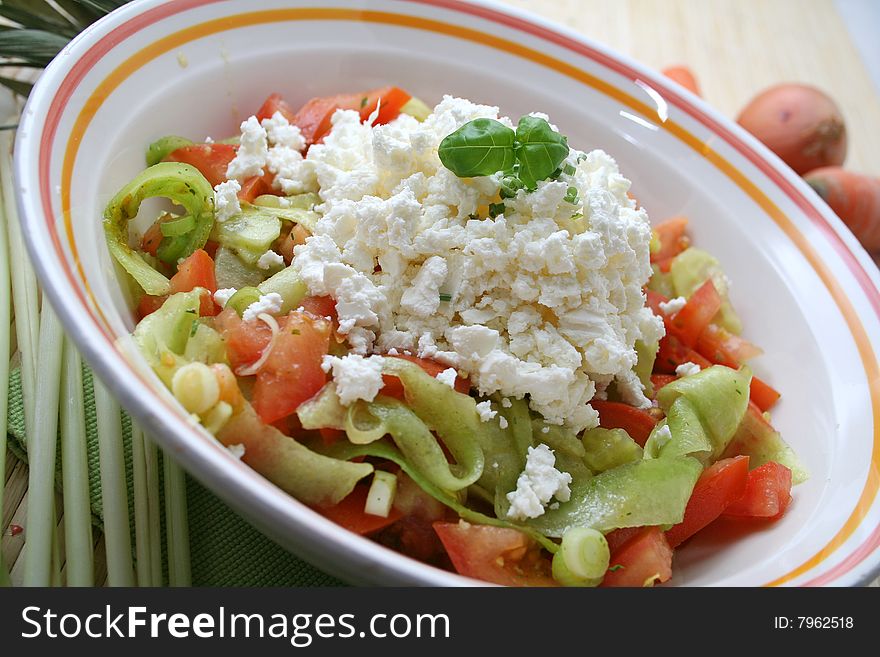 A fresh salad of cucumbers and tomatoes with cheese