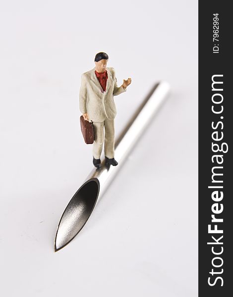 Miniature Business man standing on large bore needle. Miniature Business man standing on large bore needle