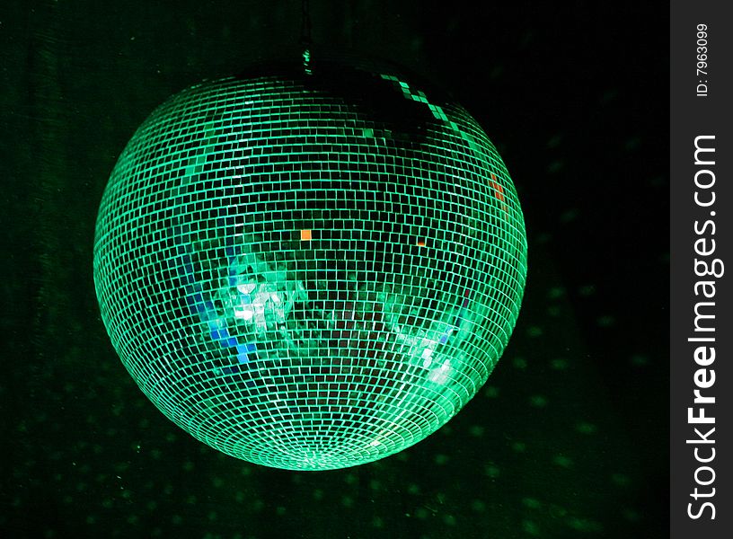 Night club lighting green mirror-ball over black