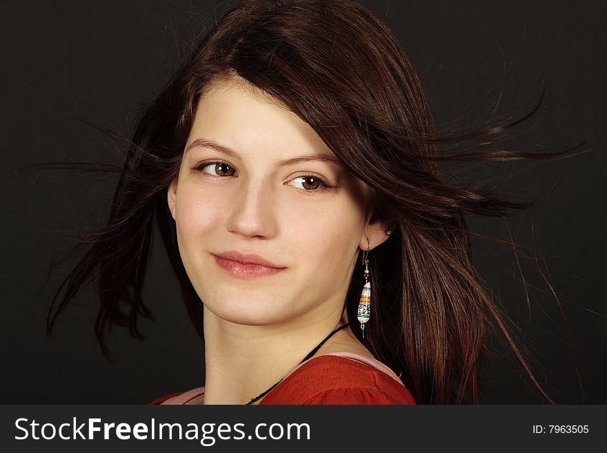 Pretty teen age girl looking away with redhead and hair flowing in the air isolated on black. Pretty teen age girl looking away with redhead and hair flowing in the air isolated on black