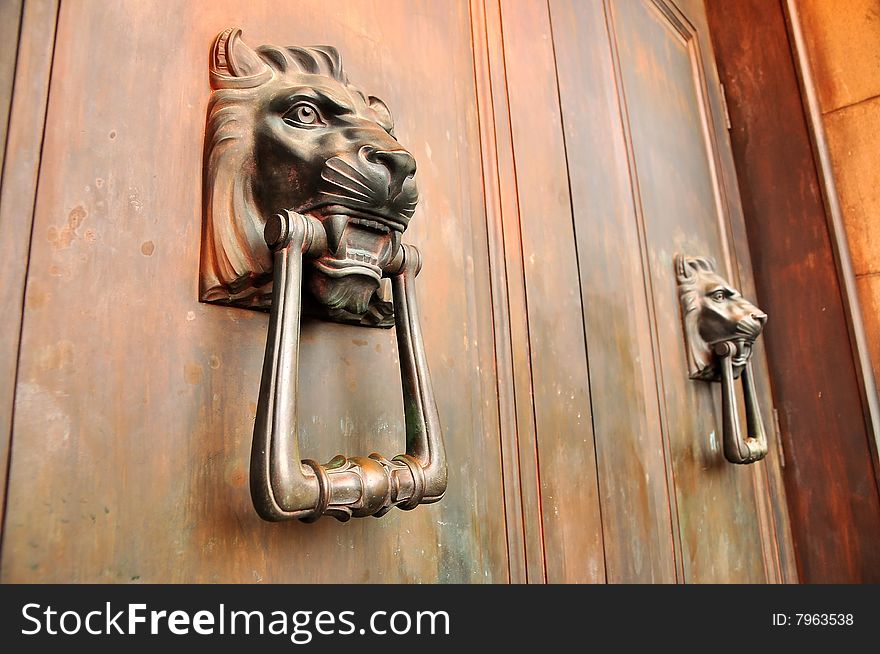 Unique lion door handles on wooden door. Unique lion door handles on wooden door