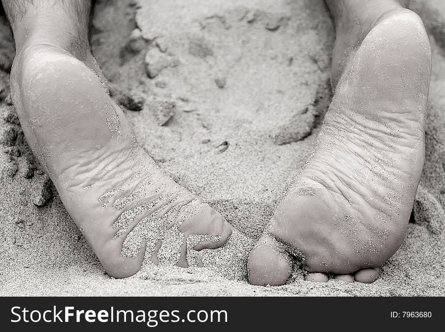 Man feet relaxing on the beach