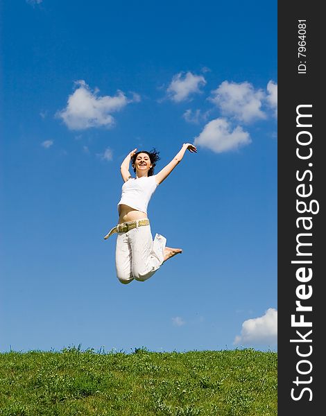 Happy young woman is jumping in green grass. Happy young woman is jumping in green grass