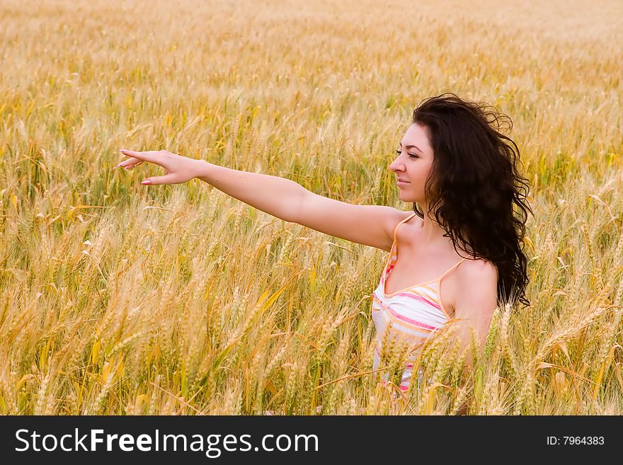 The happy young woman on a yellow field of wheat. The happy young woman on a yellow field of wheat