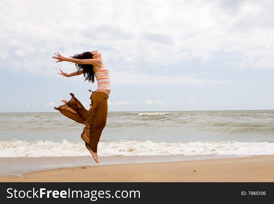 Happy woman is jumping in beach