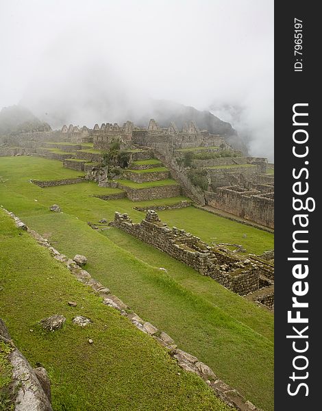 Machu Picchu is a pre-Columbian Inca site located 2,430 metres (8,000 ft) above sea level. It is situated on a mountain ridge above the Urubamba Valley in Peru, which is 80 kilometres (50 mi) northwest of Cusco and through which the Urubamba River flows.