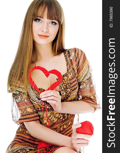 Young blond holding a red knit heart. Young blond holding a red knit heart