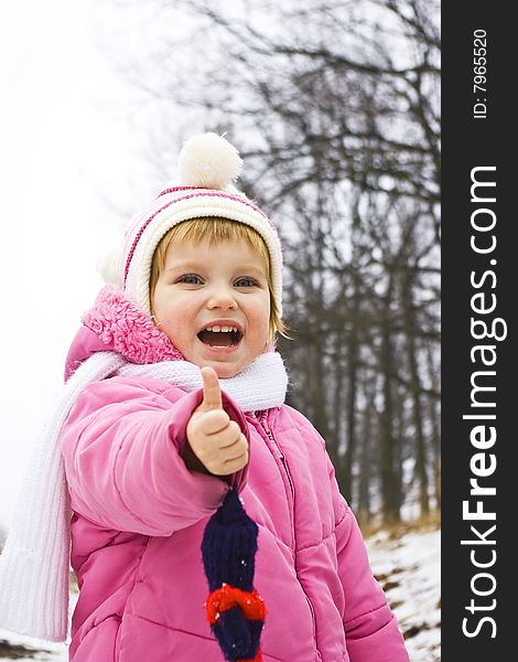 Smiling baby in pink jacket on the winter background