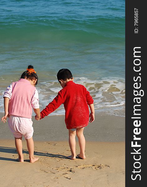 Young Kids Playing in the surfy beach