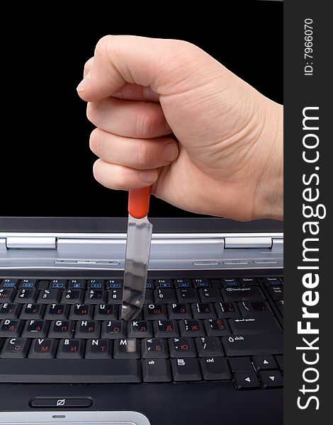 Hand with a knife in the laptop keyboard