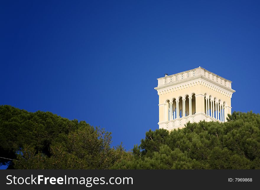 A white watch tower seen across pine trees