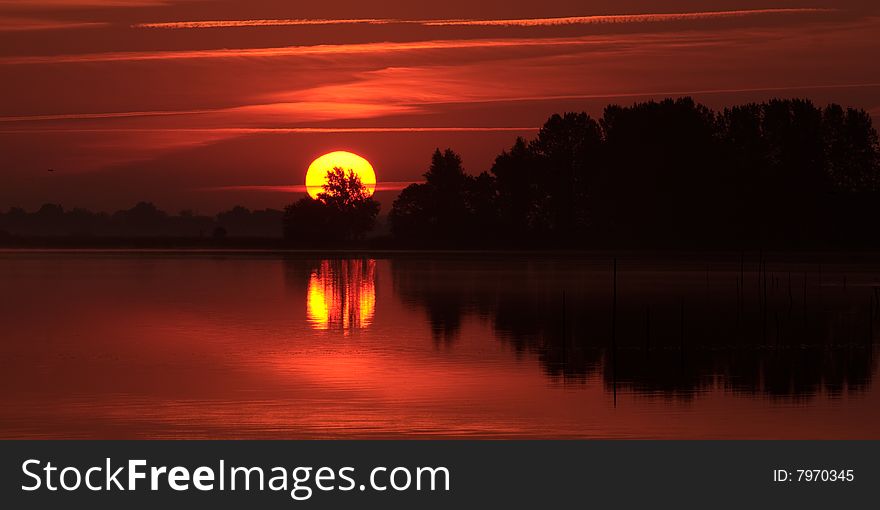 The sun rising over a lake in northern holland. The sun rising over a lake in northern holland