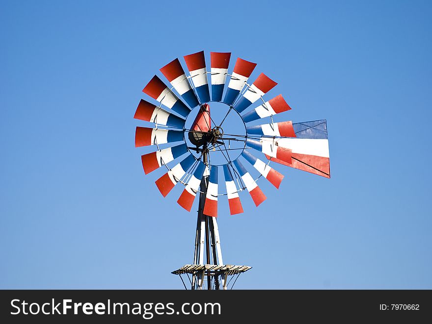 Closeup of an agricultural windmill painted red, white, and blue. Closeup of an agricultural windmill painted red, white, and blue