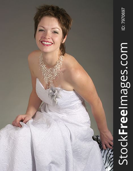 Happy bride on gray background