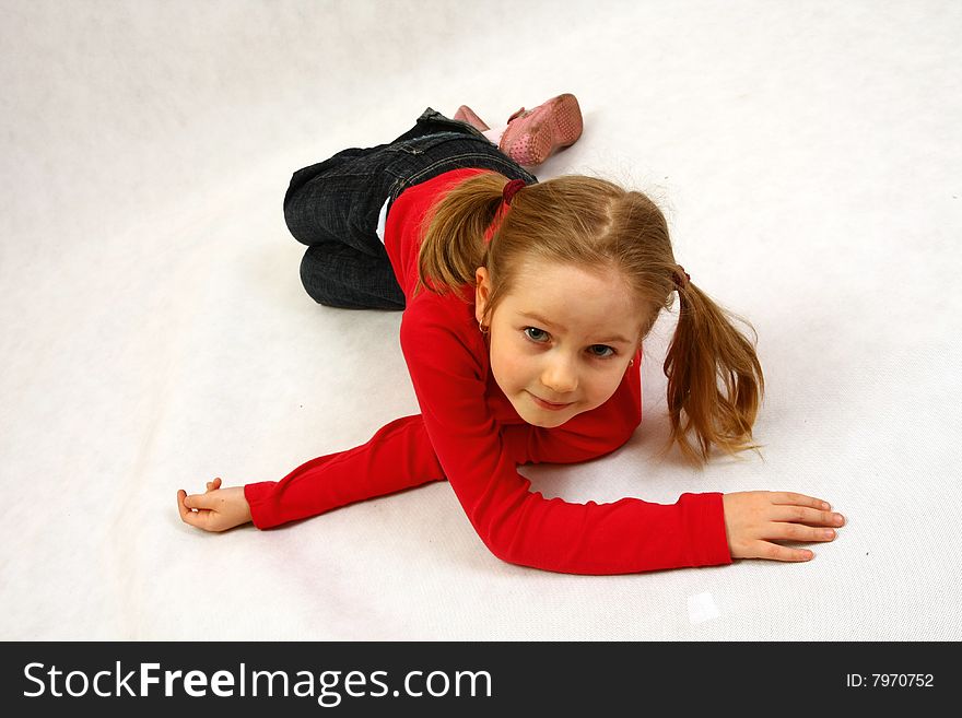 Young child isolated. Portrait of a girl dancing and moving on the floor. Young child isolated. Portrait of a girl dancing and moving on the floor.