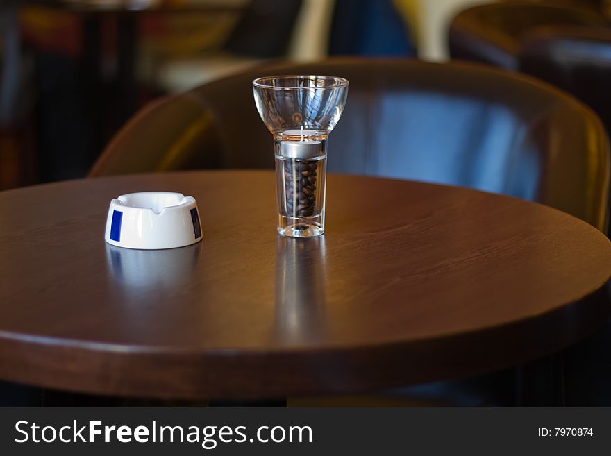 Ashtray and a glass full of coffee beans. Ashtray and a glass full of coffee beans