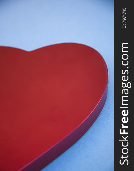 A close-up of a red heart shaped symbol on a blue background. A close-up of a red heart shaped symbol on a blue background