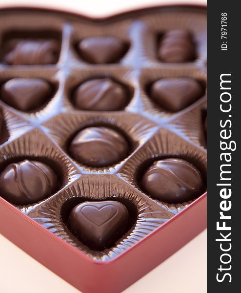 A close-up shot of valentine's day chocolates with the focus on the foreground of a heart shaped chocolate. A close-up shot of valentine's day chocolates with the focus on the foreground of a heart shaped chocolate