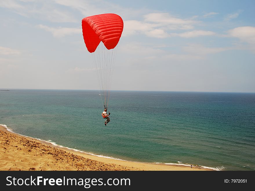 Man flying on a parachute in a desert