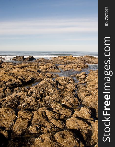 A vertical landscape of a rocky shoreline and some sky. A vertical landscape of a rocky shoreline and some sky.