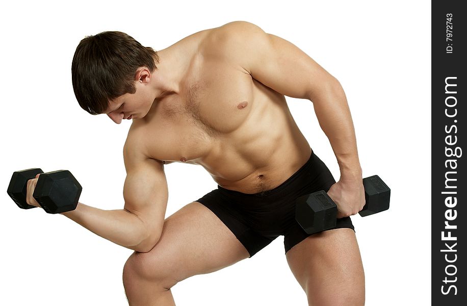 The young man does exercise with dumbbell. The young man does exercise with dumbbell