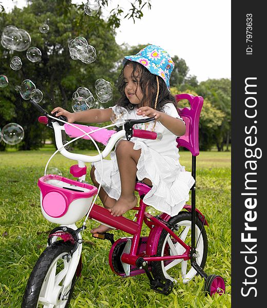 Asian girl in the garden riding her cycle