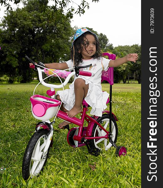 Girl In The Garden Riding Her Cycle