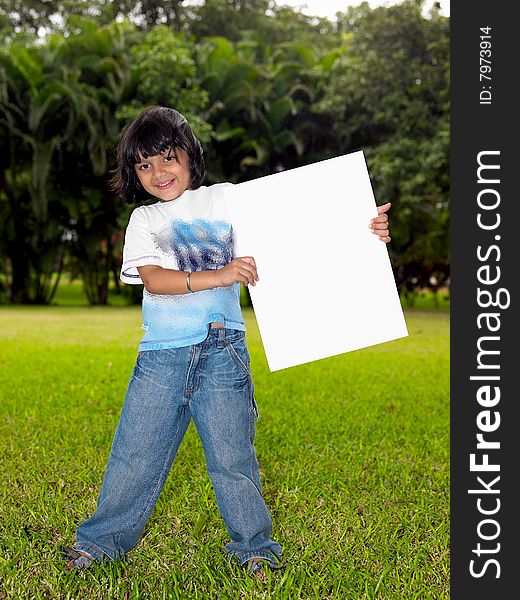 Girl with a blank placard in the garden