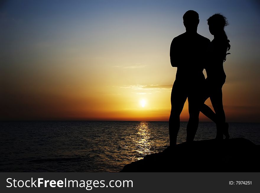 Silhouette of in love couple  on a background sea sunset