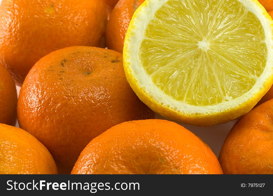 Yellow lemon on orange mandarines. Yellow lemon on orange mandarines