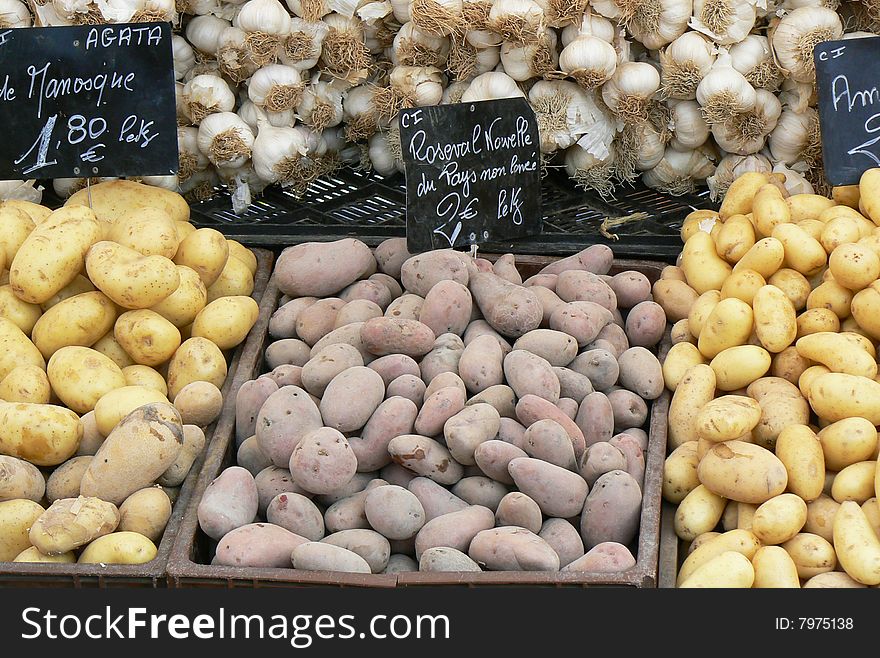 Stand in the market with garlic and potatoes