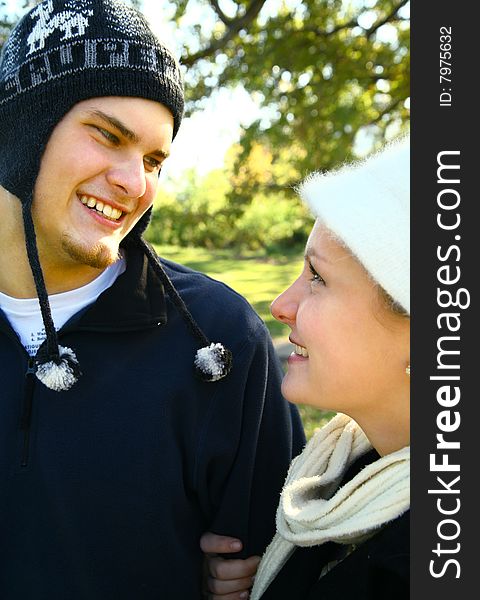 Two nice romantic young caucasian couple in urban style walking in the park. Two nice romantic young caucasian couple in urban style walking in the park