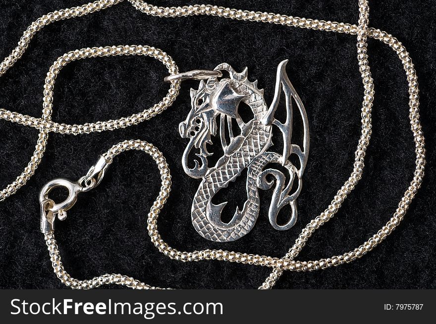 On a black drapery a silver necklace on a graceful chain. On a black drapery a silver necklace on a graceful chain.