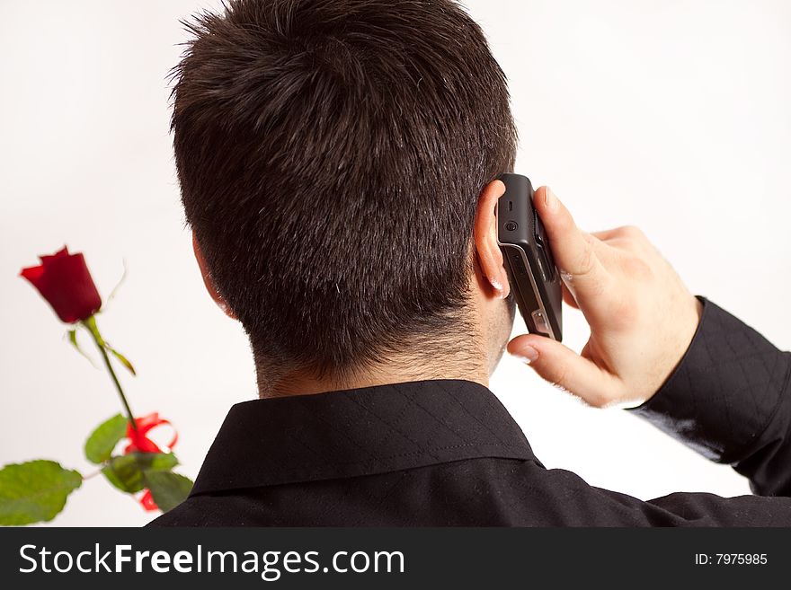 Man arranging a date via telephone and holding a rose. Man arranging a date via telephone and holding a rose
