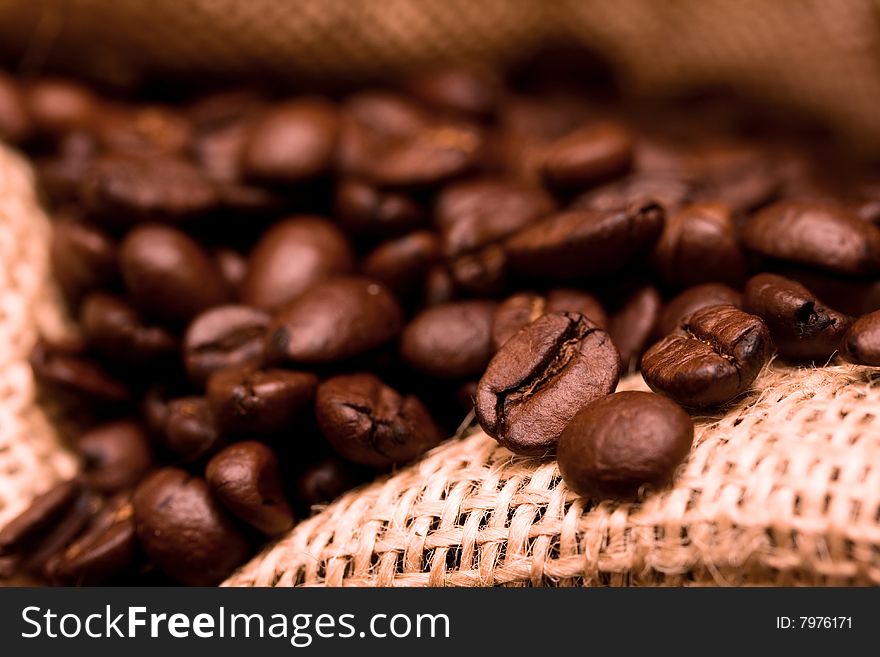 Inside burlap bag filled with coffee beans - selected focus. Inside burlap bag filled with coffee beans - selected focus