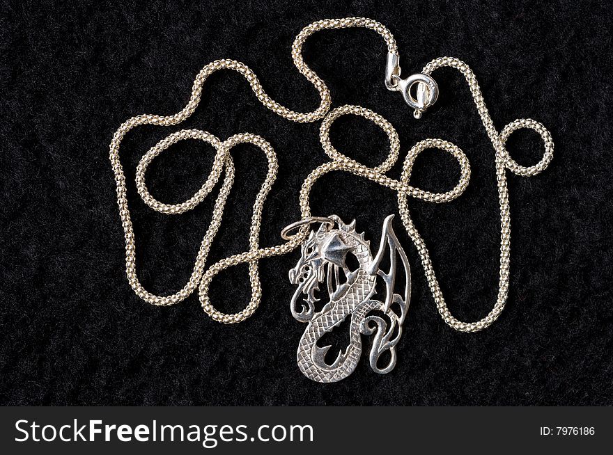 On a black drapery a silver necklace on a graceful chain. On a black drapery a silver necklace on a graceful chain.