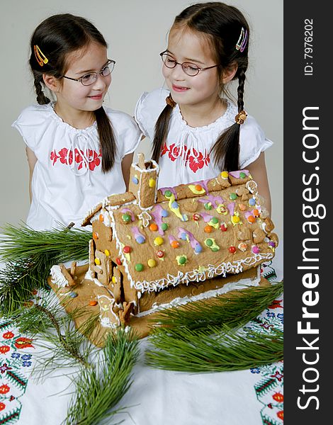 Twins decorating a gingerbread house