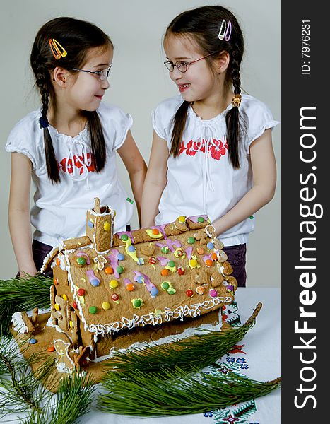 Twins decorating a gingerbread house