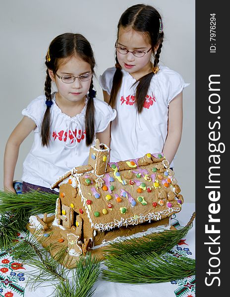 Twins decorating a gingerbread house