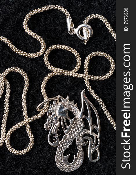 On a black drapery a silver necklace on a graceful chain. On a black drapery a silver necklace on a graceful chain.