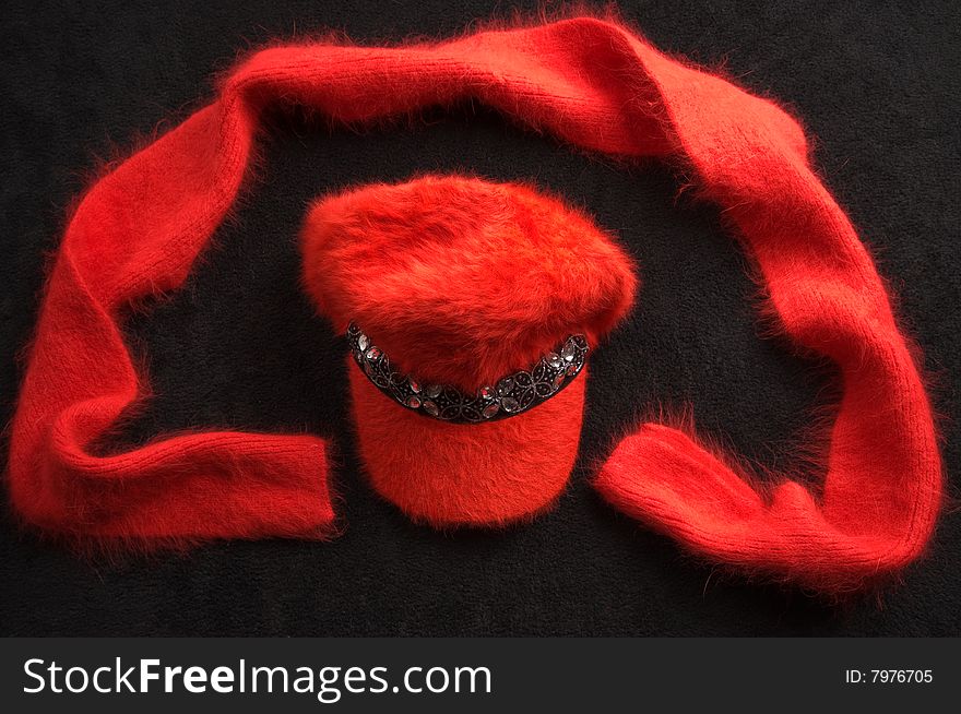 Red cap and scarf on a black drapery. Red cap and scarf on a black drapery.