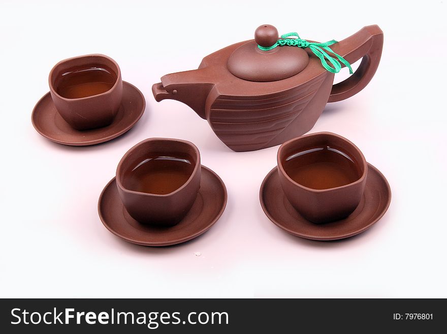 A set of Chinese traditional tea sets are on the white and pink background.