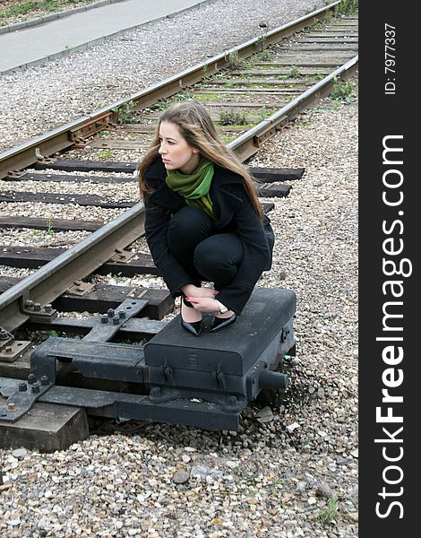 A girl sitting near railroad