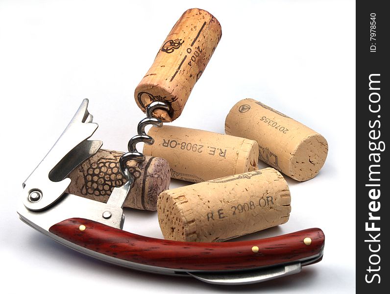 Corkscrew and several wine corks isolated on white