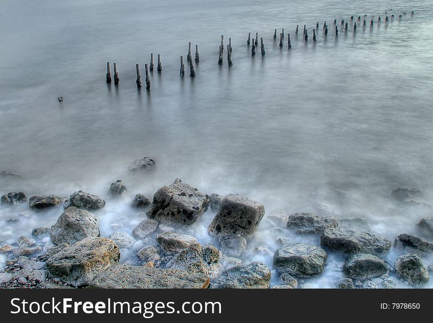 Old wooden columns at a destroyed pier. Old wooden columns at a destroyed pier