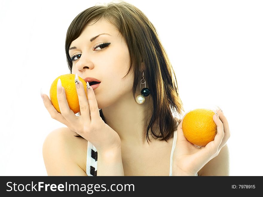 Sexy brunette woman eating oranges